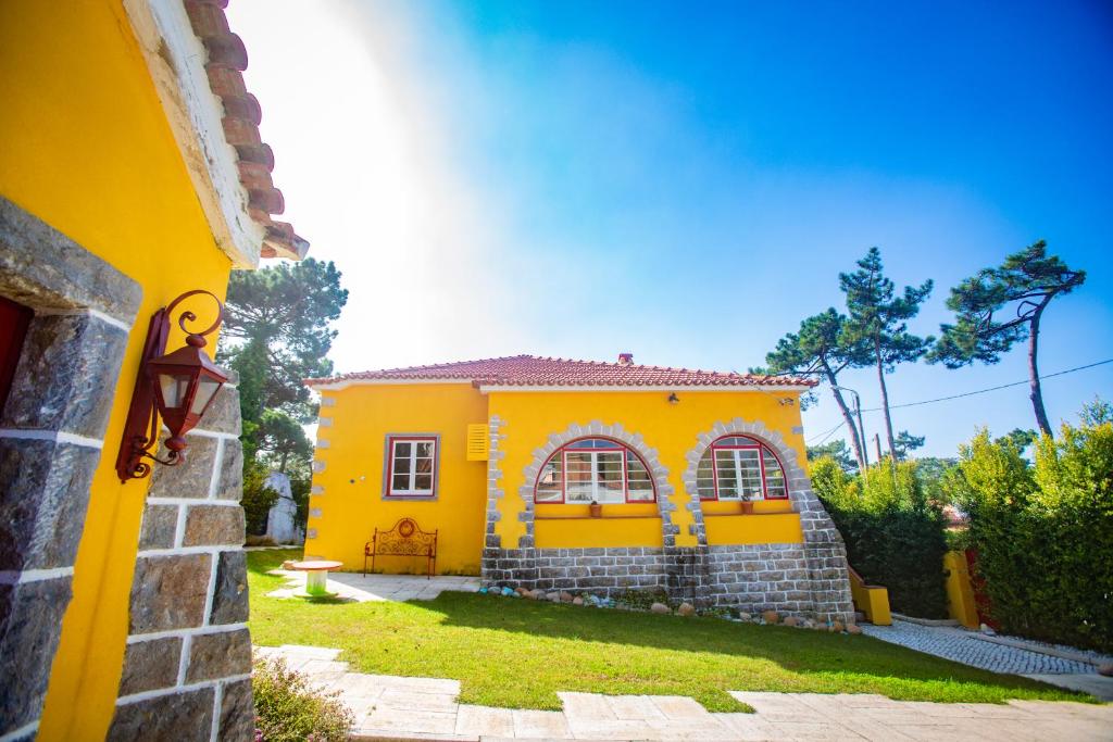 una pequeña casa amarilla con un patio con un patio en A Barca Charm House, en Sintra