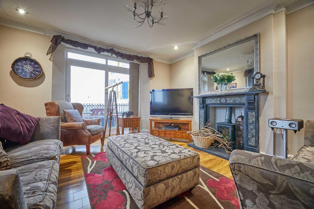 ein Wohnzimmer mit Kamin und Fernseher in der Unterkunft Host & Stay - The View Old Coastguard Cottage in Tynemouth