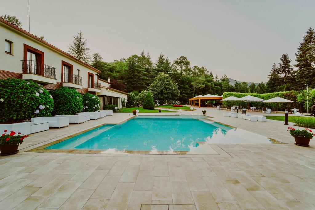 a swimming pool in the middle of a courtyard at CAN MARLET MONTSENY Hotel Boutique in Montseny