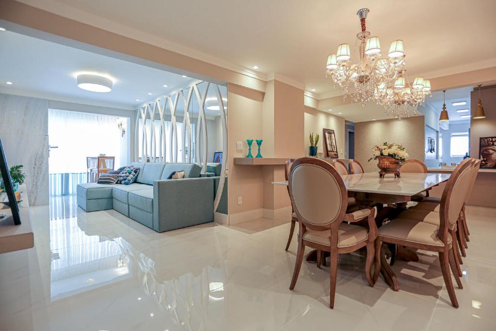 a dining room and living room with a table and chairs at Luxo e Conforto a Beira Mar em Balneário Camboriu in Balneário Camboriú