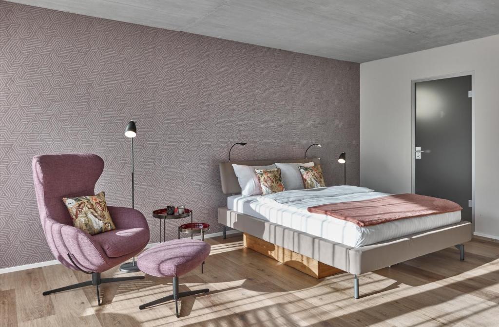 1 dormitorio con 1 cama y 1 silla en BoHo by Maier - kontaktloser Check-In, en Buchs