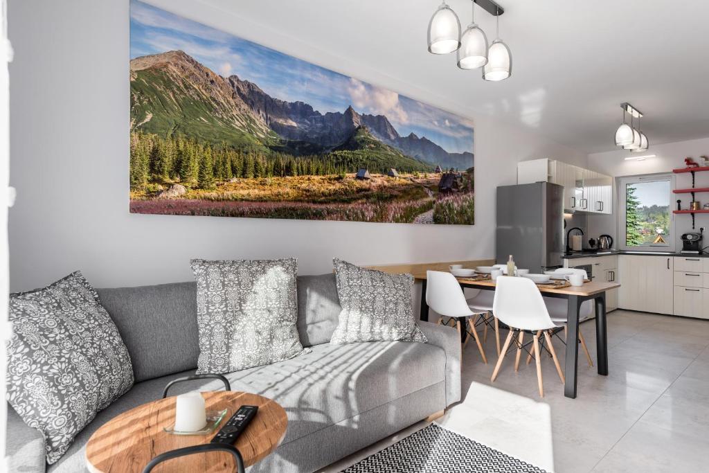 a living room with a gray couch and a table at Apartament Biathlon in Kościelisko