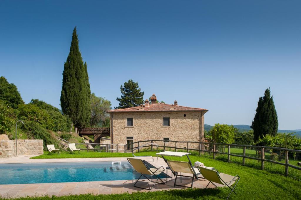 une villa avec une piscine et deux chaises dans l'établissement Villa Bottaia - Homelike Villas, à Molinelli
