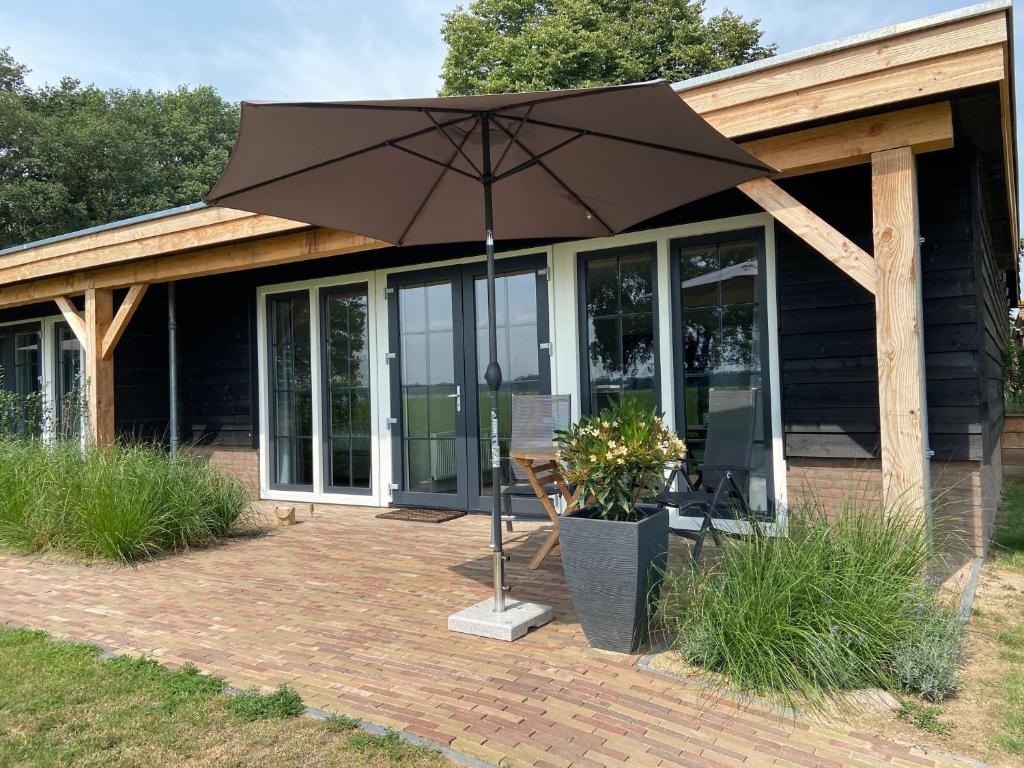 patio con ombrellone di fronte a casa di Hof van Lenthe appartement De Mars a Dalfsen
