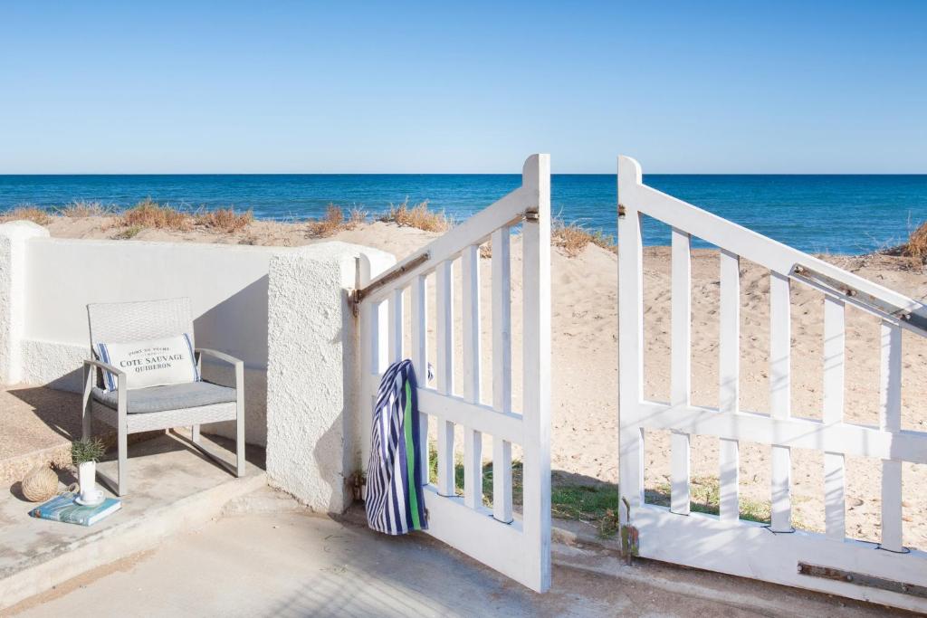 un escalier menant à la plage avec une chaise dans l'établissement Mi Casita 29, à Dénia