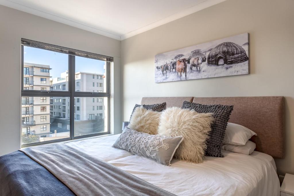 a bedroom with a bed with a large window at The Paragon Urbane CENTRALLY LOCATED, MODERN COMFORTS in Cape Town