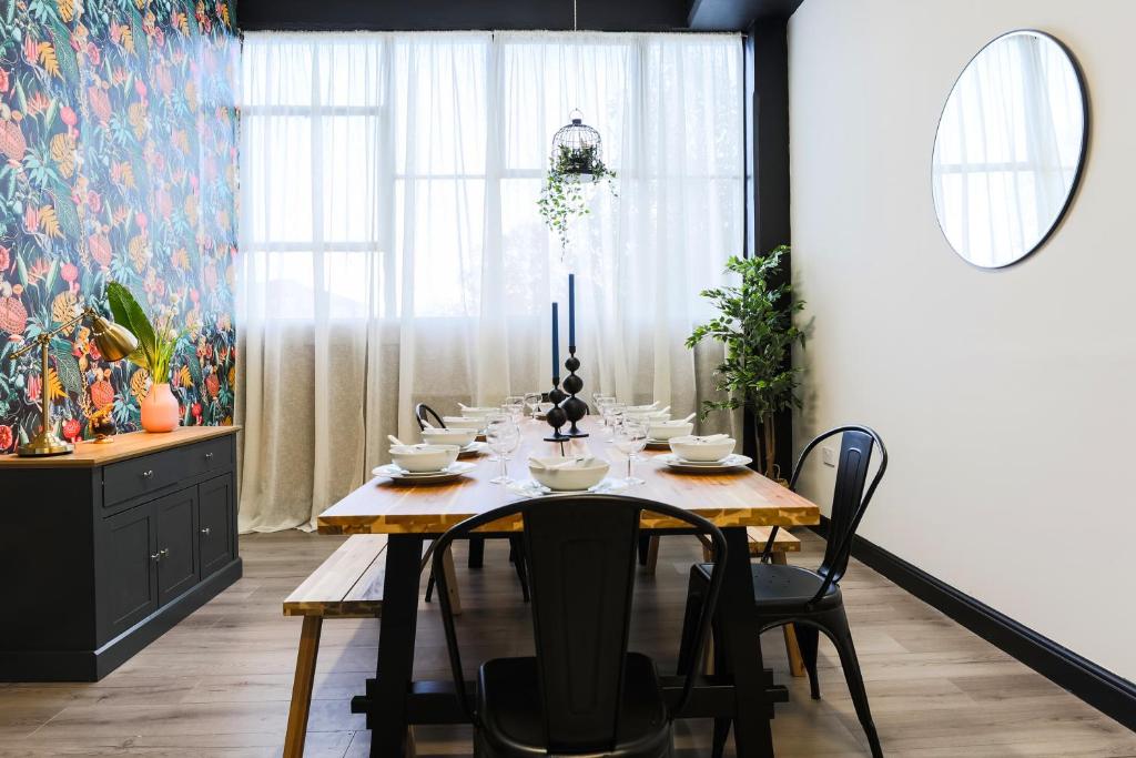 a dining room with a wooden table and chairs at The DreamArt Warehouse in London