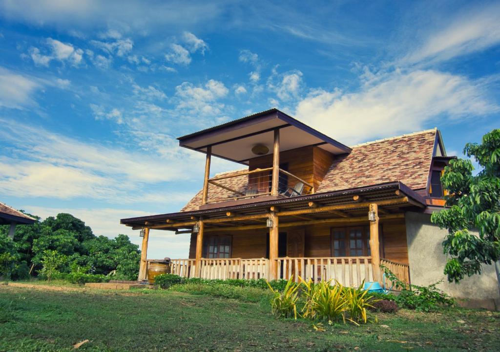 une maison en bois avec un toit en gambrel dans l'établissement Cozycomo Chiang Dao - Pha Mok, à Amphoe Chiang Dao