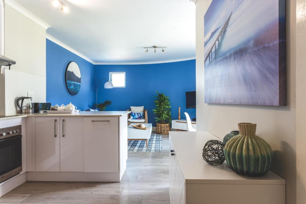 cocina y comedor con paredes azules en The Paragon KAHLÚA Modern Open Plan Centrally Located, en Ciudad del Cabo