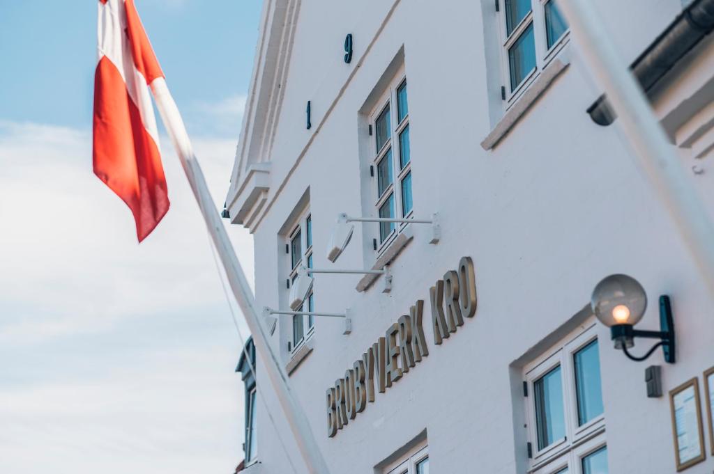 un edificio con una bandera y una señal en él en Brobyværk Kro en Brobyværk