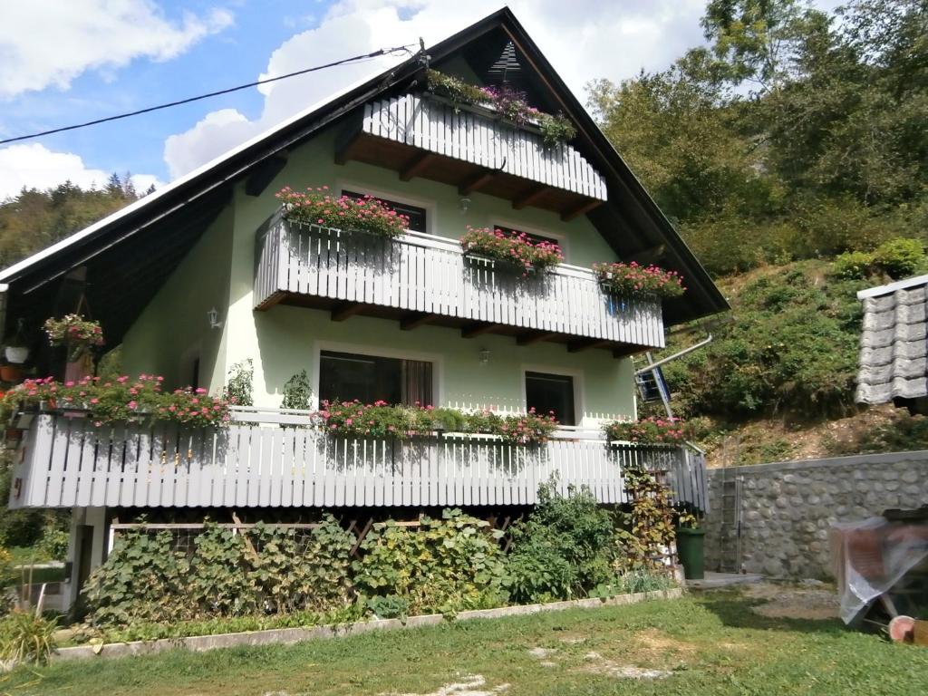 una casa con balcones blancos y flores en ella en Apartment Žvan, en Bohinj