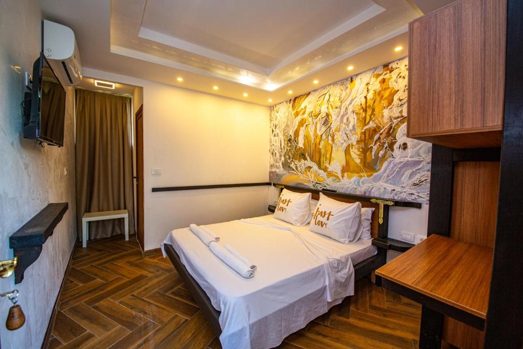 una habitación de hotel con una cama y un cuadro en la pared en Hotel Legjenda en Shkodër