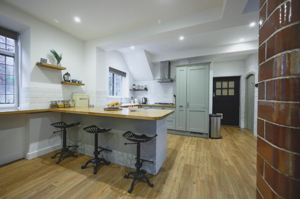 - une cuisine avec un comptoir et des tabourets dans une pièce dans l'établissement The Old Cook's House, à Hindhead
