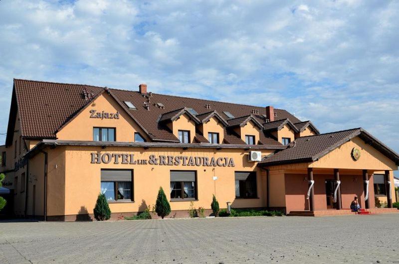 un grand bâtiment avec un panneau à l'avant dans l'établissement Zajazd Motel Staropolski, à Pyskowice