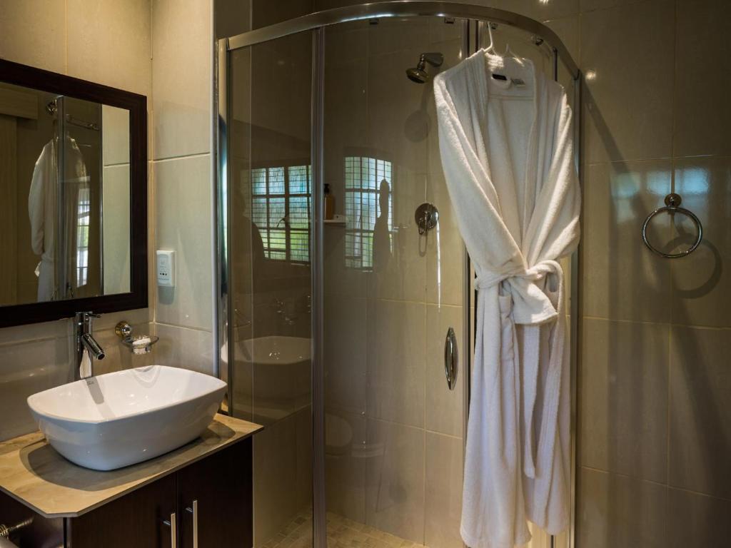 a bathroom with a shower with a sink and a tub at Gallo Manor Executive Bed & Breakfast in Johannesburg