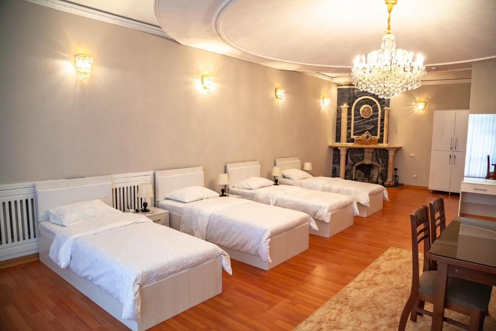 Ridon Lux Hotel في طشقند: غرفة بثلاث اسرة وثريا