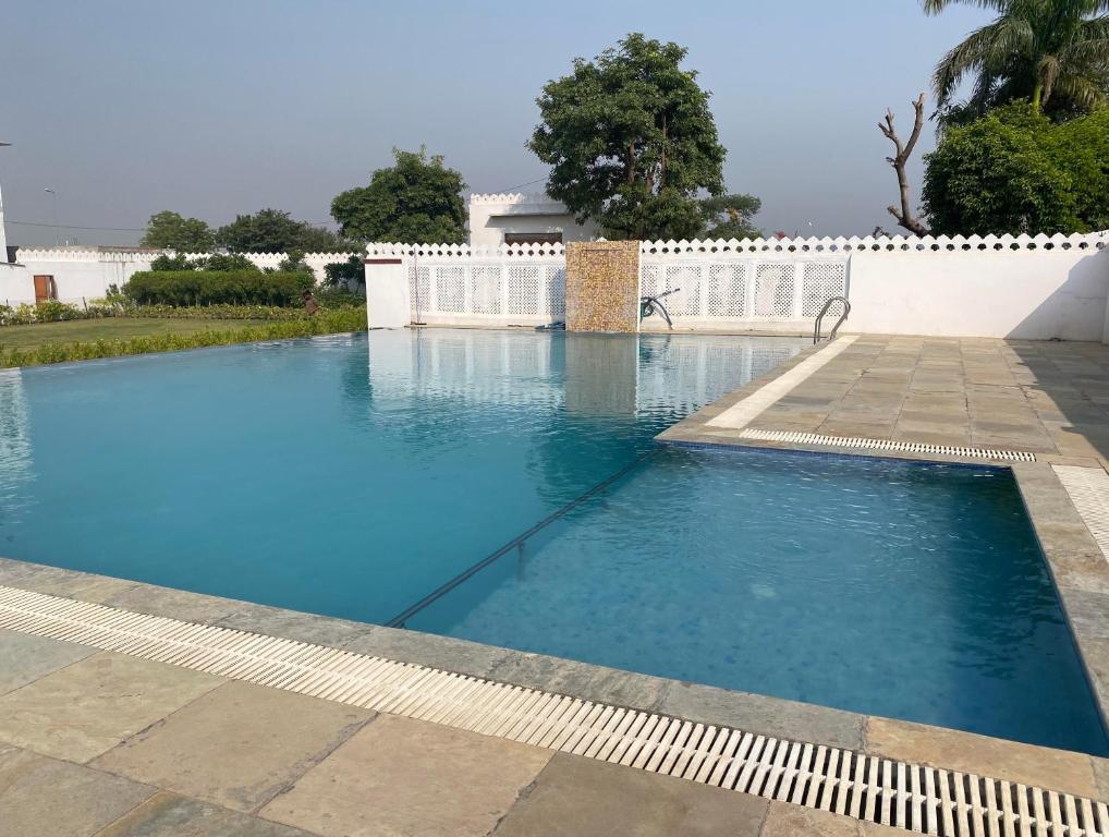 a large blue swimming pool with a white fence at Roop Shree Hotel in Chittaurgarh