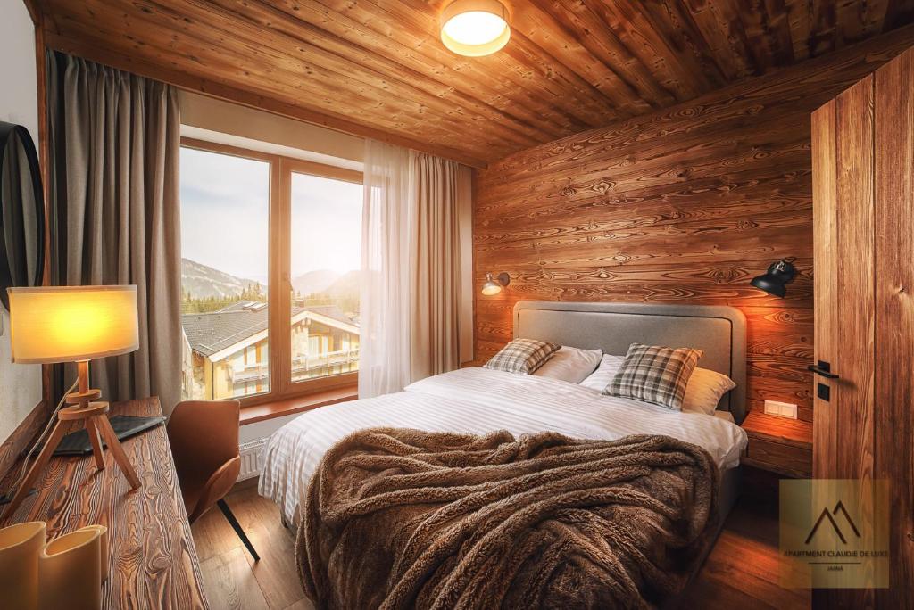 a bedroom with a bed and a large window at Apartment Claudie de Luxe in Demanovska Dolina