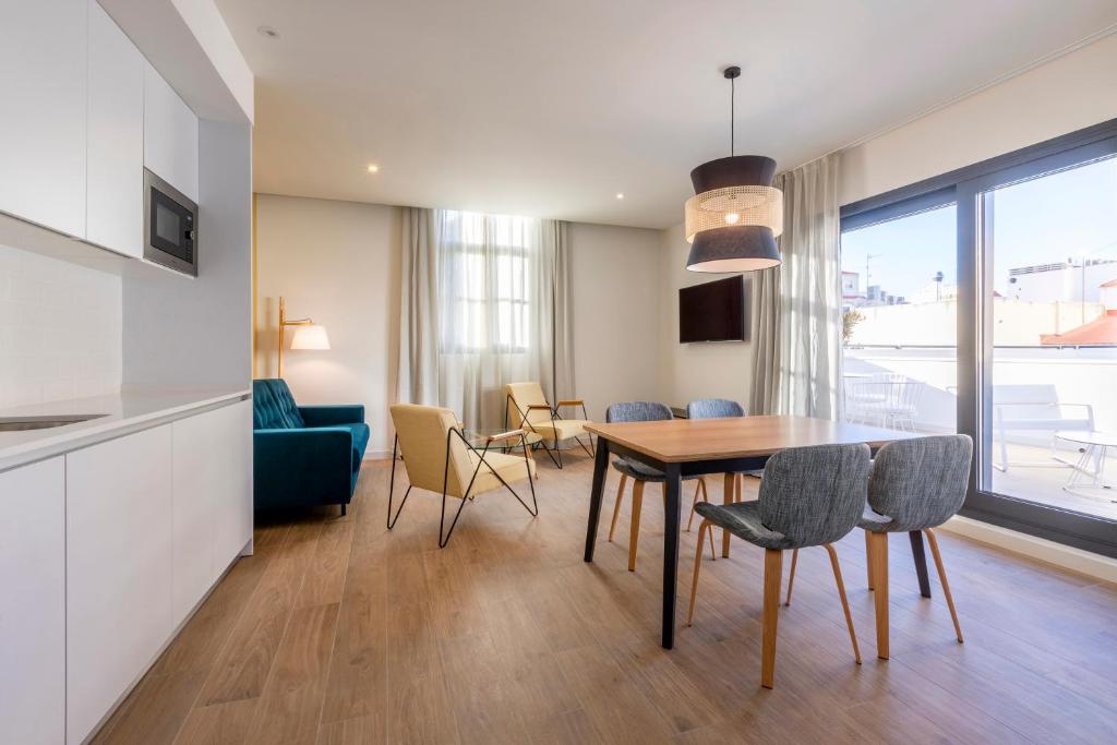 a kitchen and dining room with a table and chairs at Tandem Portal De Elche in Alicante