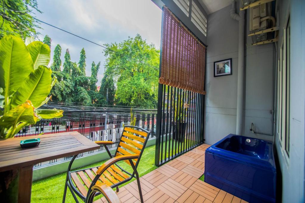 a patio area with chairs, a table, and a patio umbrella at The Artist Residence in Phnom Penh