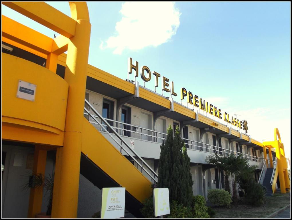 un hotel con un edificio amarillo con un cartel en él en Premiere Classe Chantilly Sud Luzarches, en Chaumontel