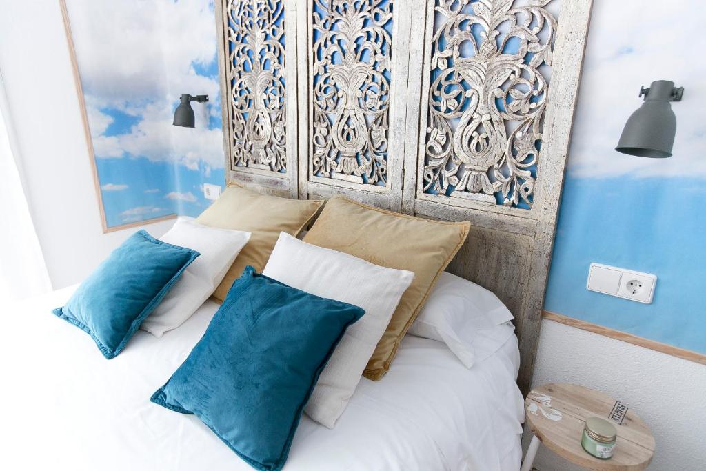 ein Schlafzimmer mit einem Bett mit blauen und weißen Kissen in der Unterkunft Vázquez de Mella Gran Vía in Madrid