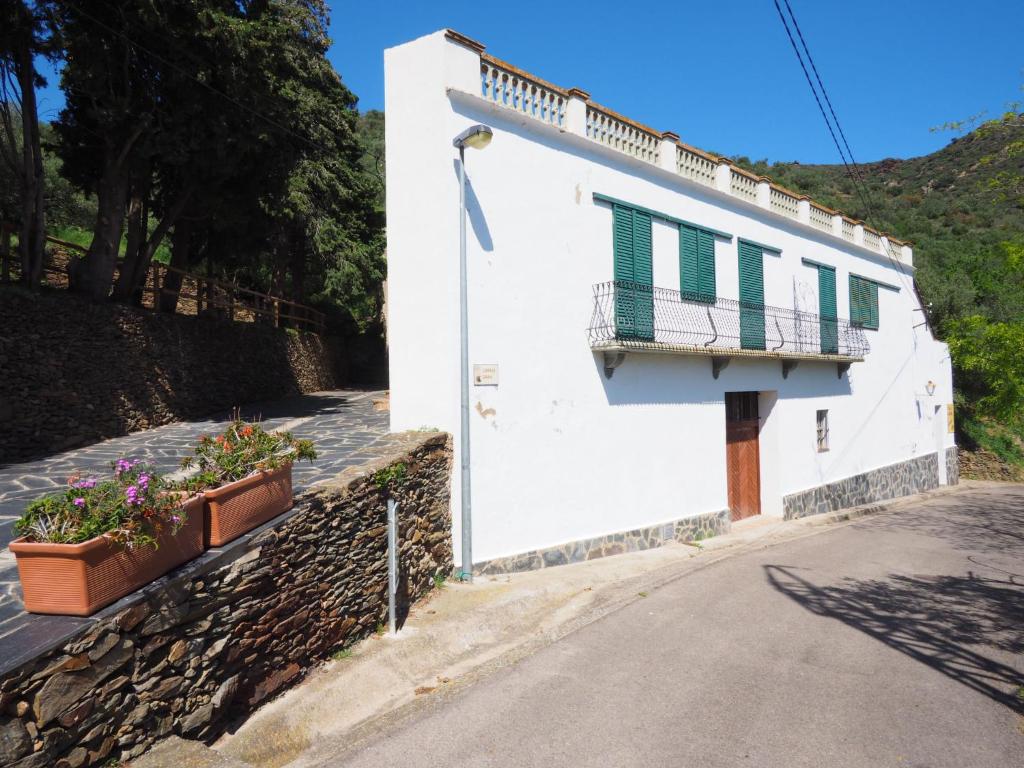 Apartment La Rectoria II by Interhome في La Vall de Santa Creu: مبنى أبيض مع شرفة وورود على الحائط