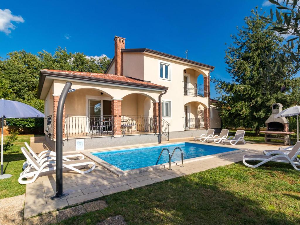 a villa with a swimming pool in front of a house at Holiday Home Lara by Interhome in Vrsar