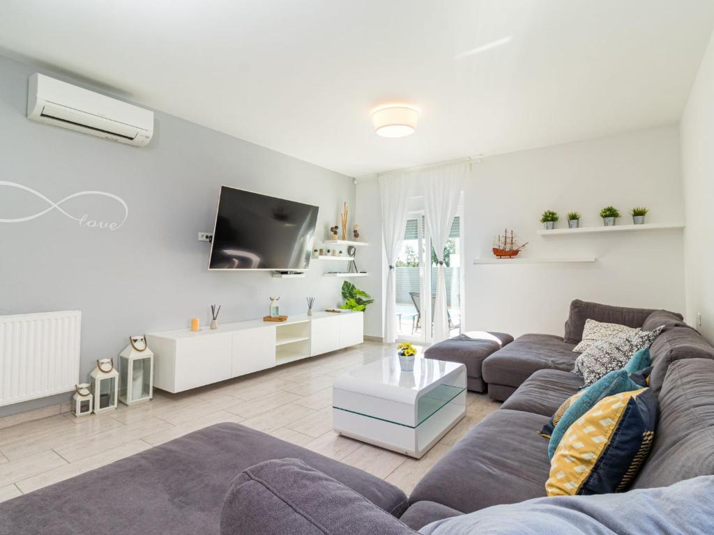 salon z kanapą i telewizorem w obiekcie Holiday Home Villa Virtus by Interhome w mieście Brtonigla