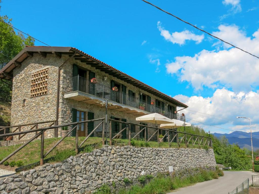 uma casa numa colina com uma parede de pedra em Holiday Home Del Regolo by Interhome em Molazzana