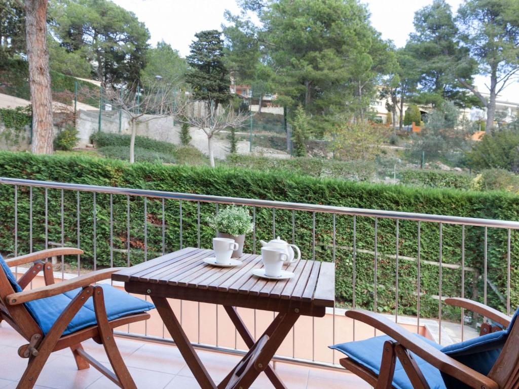 a wooden table and two chairs on a balcony at Apartment Escorxador by Interhome in L'Escala