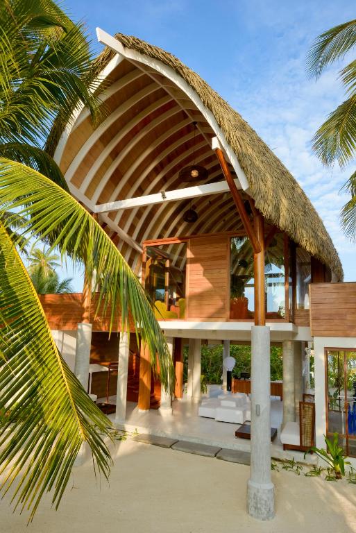a house on the beach with a straw roof at Kandolhu Maldives in Himandhoo 