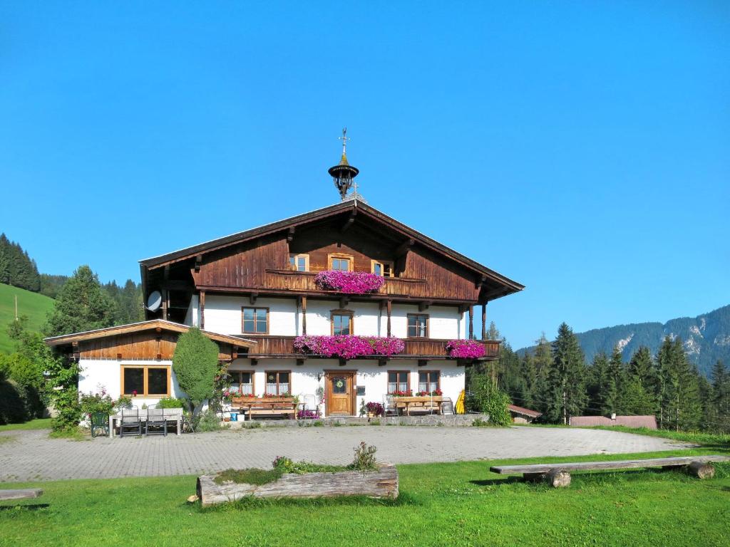 a large wooden house with flowers in front of it at Holiday Home Schwalbenhof - WIL330 by Interhome in Oberau