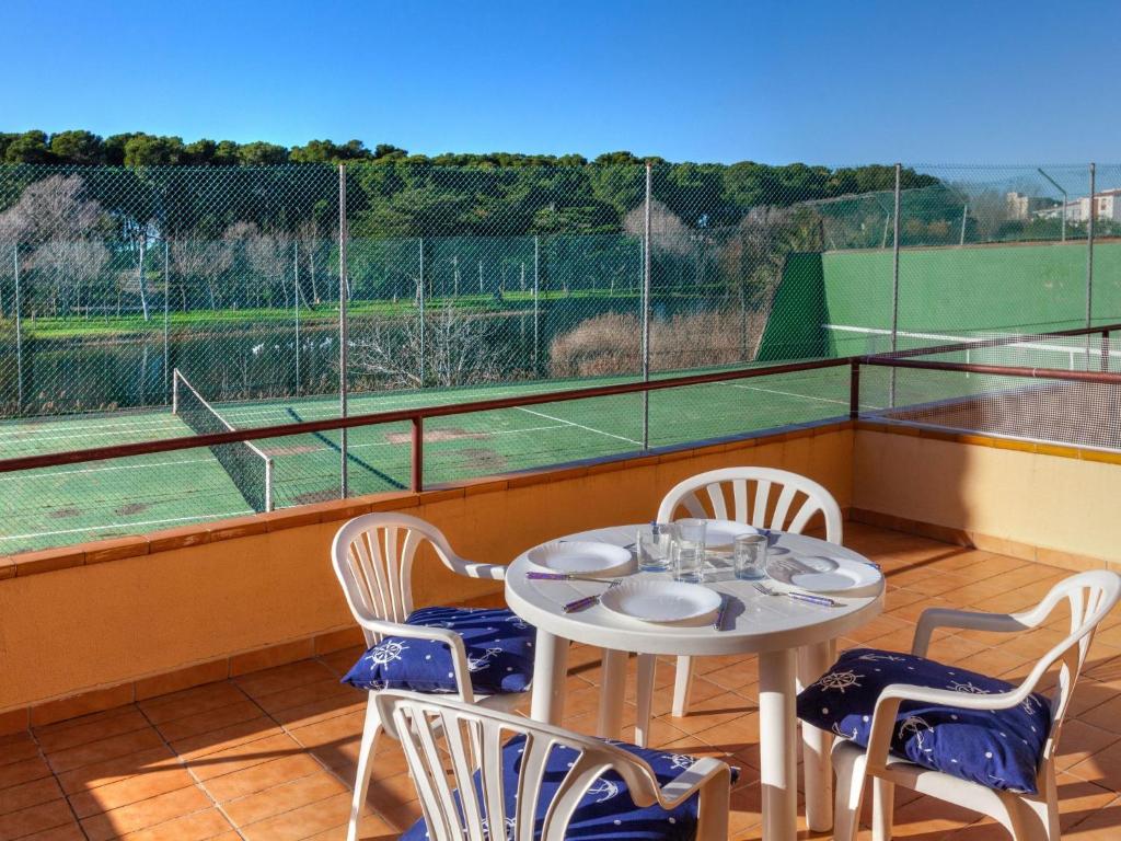 レスカラにあるApartment Del Lago by Interhomeのテニスコート付きのバルコニー(テーブル、椅子付)