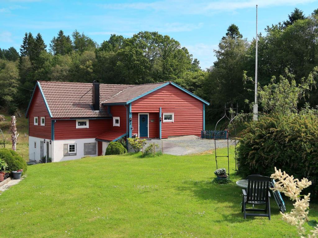 une maison rouge et blanche avec une cour dans l'établissement Holiday Home Rødehuset - FJH670 by Interhome, à Gjelland