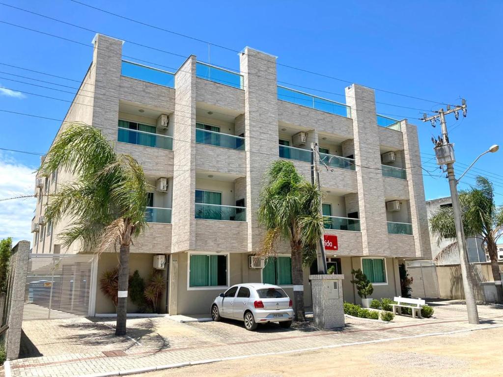 a building with a car parked in front of it at Residencial Florida in Bombinhas