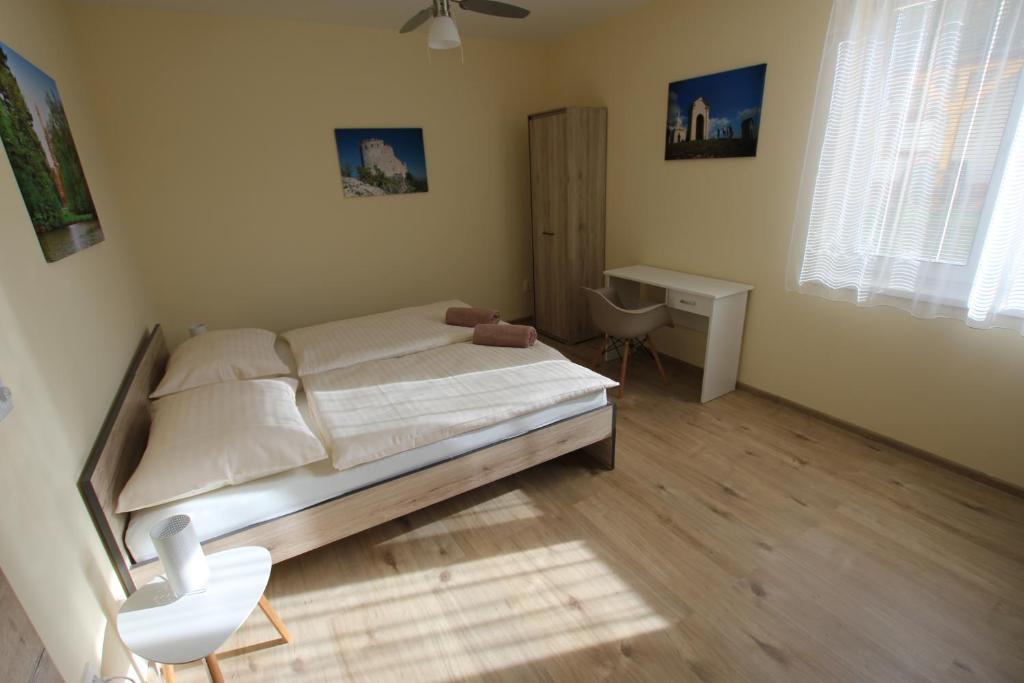um quarto com uma cama e uma secretária. em Comenius Moravus vinařský dvůr em Mikulov