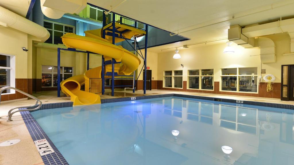 - une piscine avec toboggan dans un bâtiment dans l'établissement Holiday Inn Express Hotel & Suites - Edmonton International Airport, an IHG Hotel, à Nisku