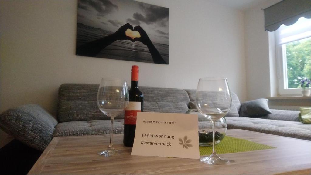 uma mesa com dois copos de vinho e um cartaz em Kastanienblick em Sankt Andreasberg