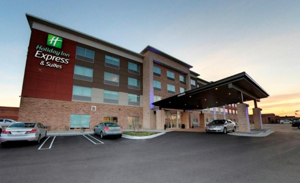 a hotel with cars parked in a parking lot at Holiday Inn Express & Suites - Detroit North - Roseville, an IHG Hotel in Roseville