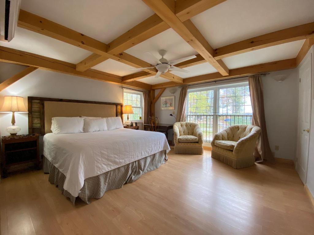 a bedroom with a large bed and two chairs at Timber House Resort in Brighton