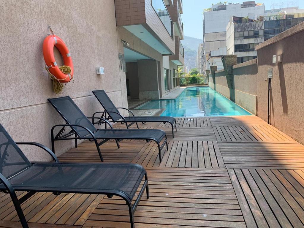 a deck with chairs and a swimming pool on a building at Condomínio Premium Suítes 02 in Rio de Janeiro