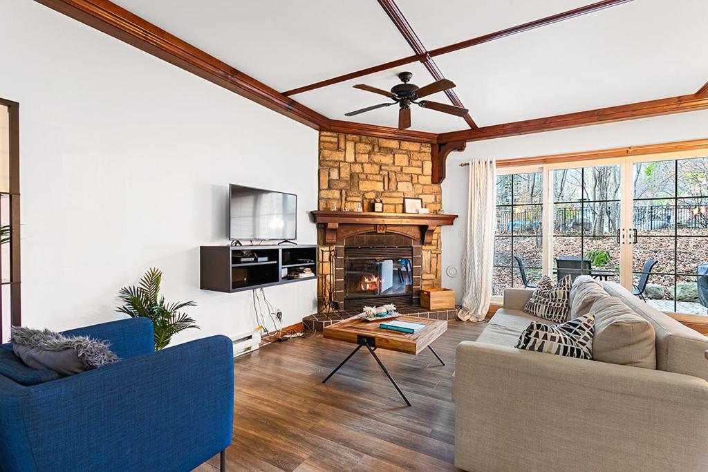 a living room with a couch and a fireplace at Le Manoir 106-7 by Escapades Tremblant in Mont-Tremblant