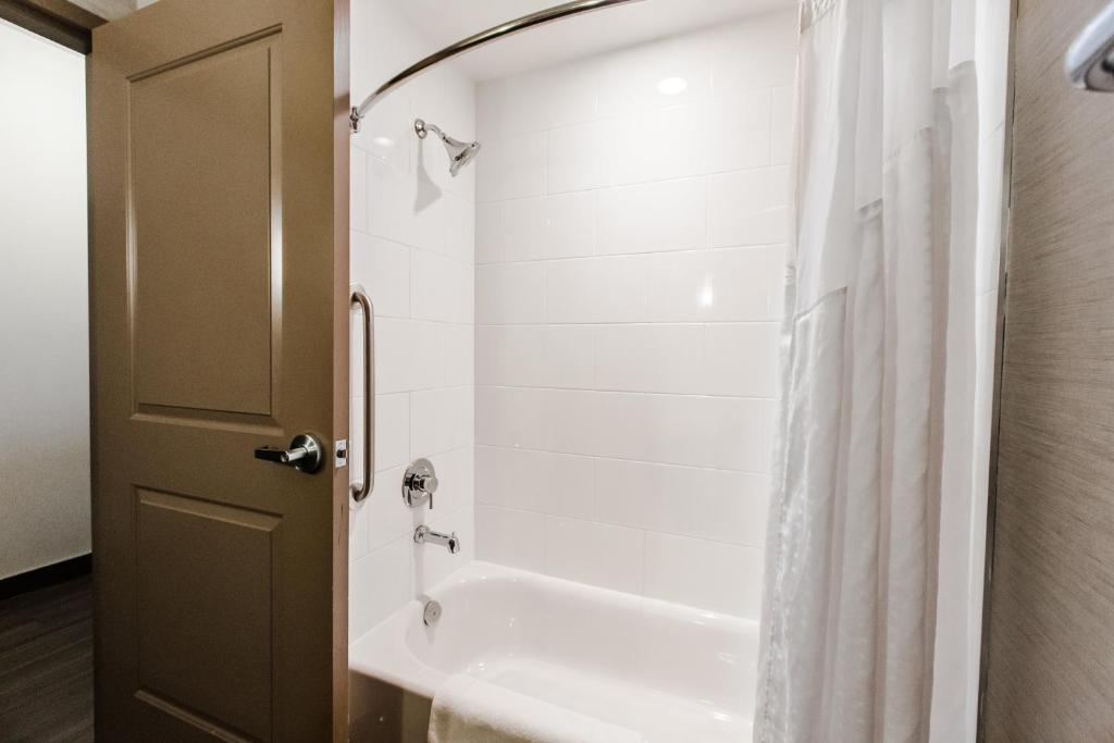 a bathroom with a shower and a white tub at Holiday Inn Express & Suites Spruce Grove - Stony Plain by IHG in Spruce Grove