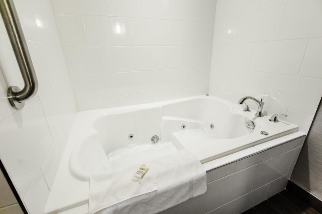 a white bath tub in a white bathroom at Holiday Inn Express & Suites Spruce Grove - Stony Plain by IHG in Spruce Grove