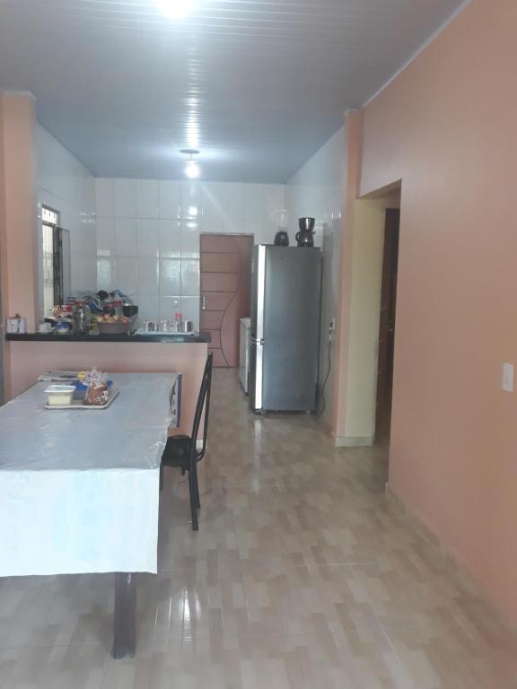 uma cozinha com uma mesa e um frigorífico de aço inoxidável em Romulo Ap2 em Manaus