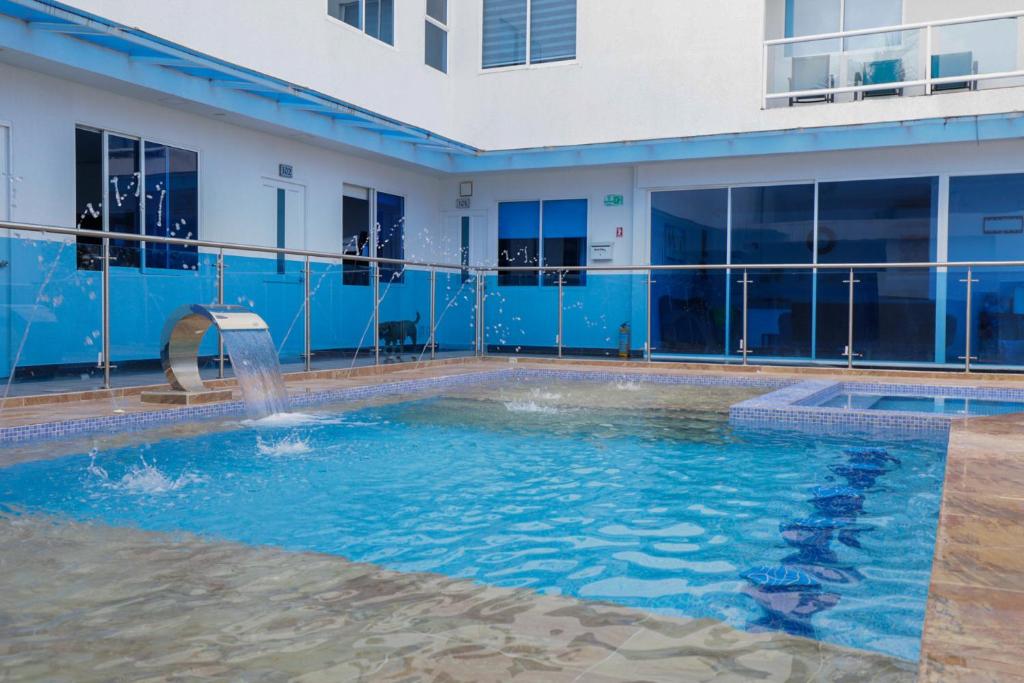 a swimming pool with a fountain in front of a building at Ocean Blue Beach in San Andrés