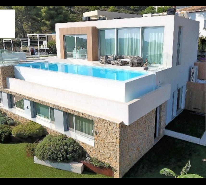 a house with a swimming pool on top of it at Villa Infinity Denia in Denia
