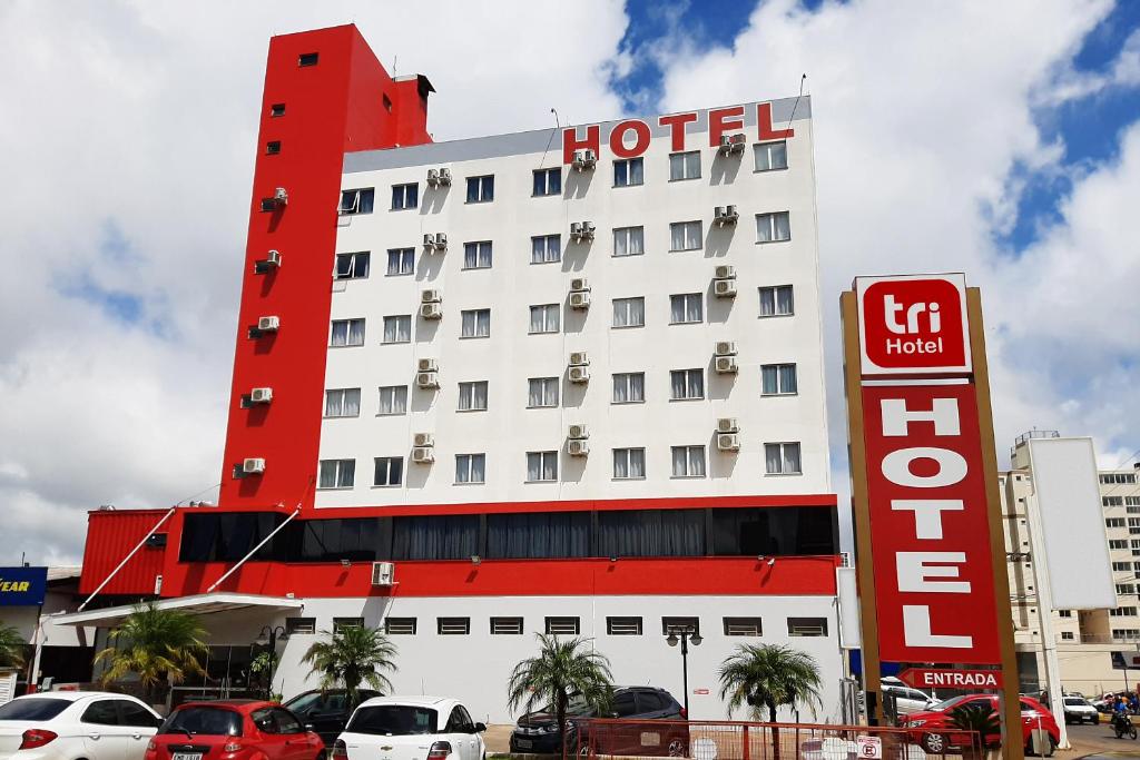 un hotel con un cartel de hotel rojo delante de él en Tri Hotel Smart Chapecó, en Chapecó