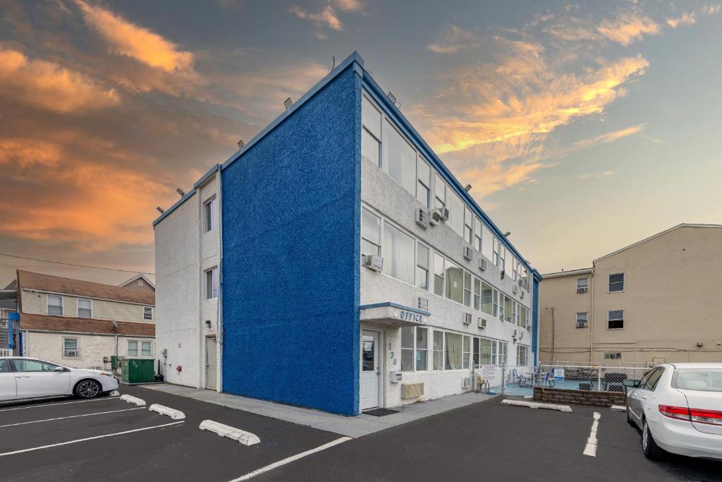 un edificio blu con auto parcheggiate in un parcheggio di AIRE Hotel North Beach Jersey Shore a Seaside Heights